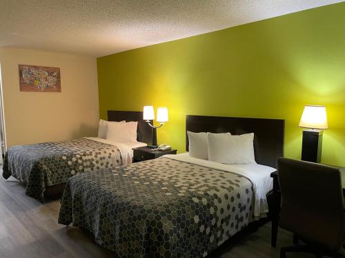 two beds in a hotel room with green walls at Econo Lodge Inn & Suites Sweetwater I-20 in Sweetwater
