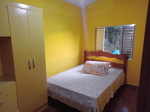 um pequeno quarto com uma cama e uma janela em Casa Natureza, Mar, Floresta e Tranquilidade em Ubatuba