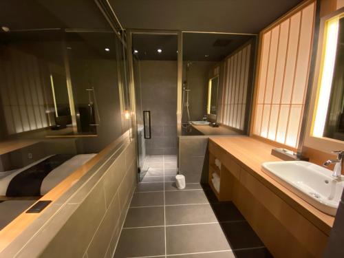 a bathroom with a sink and a bed and a tub at Hotel Zagakukan in Hakone
