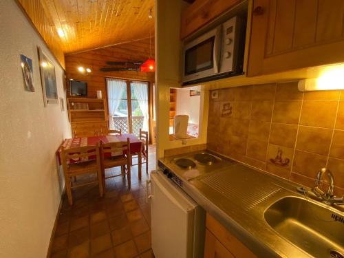 - une cuisine avec un évier et une table dans une chambre dans l'établissement Appartement calme avec Multi Pass à 3€/jour, proche du centre, des remontées et des activités d'été! - FR-1-693-20, à Châtel