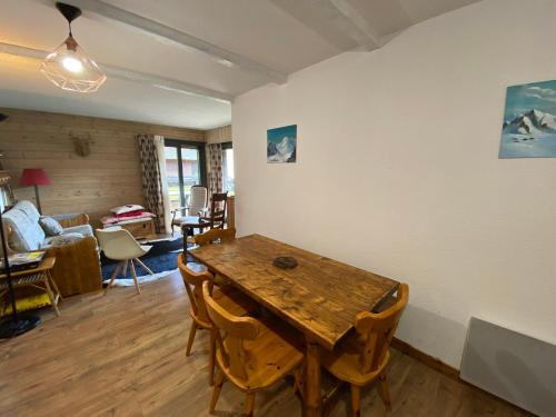un salon avec une table et des chaises en bois dans l'établissement Appartement 6 pers avec Multi Pass, à proximité des remontées Petit-Châtel et parking privé! - FR-1-693-32, à Châtel