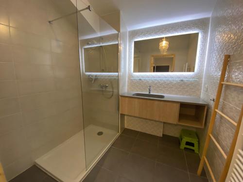 une salle de bain avec une douche, un lavabo et un miroir dans l'établissement Appartement 2è étage proche centre, 3€/jour Multi Pass, 2 ch., balcon sud, garage privé, Châtel - FR-1-693-33, à Châtel