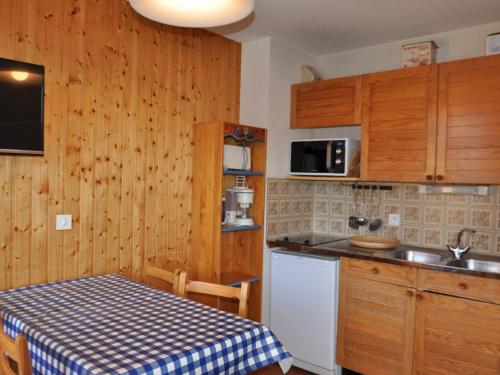 a kitchen with a table and a sink and a refrigerator at Studio cosy à 900m du centre de Châtel, balcon exposé sud/ouest, navettes à proximité - FR-1-693-29 in Châtel