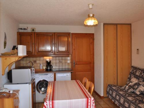 une petite cuisine avec une table et un canapé dans l'établissement Appartement cosy à 600m des pistes avec garage privatif - FR-1-693-50, à Châtel