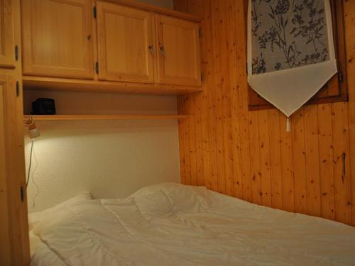 Ce lit se trouve dans un dortoir doté de murs et de placards en bois. dans l'établissement Appartement à 600m du télésiège de Petit-Châtel, Multi Pass offert, animaux acceptés sur demande. - FR-1-693-15, à Châtel