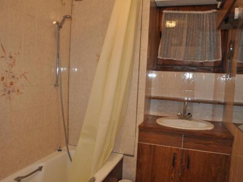 La salle de bains est pourvue d'un lavabo et d'une douche avec rideau de douche. dans l'établissement Spacieux appart avec terrasse à Châtel, proche centre et navettes, Multi Pass inclus - FR-1-693-22, à Châtel