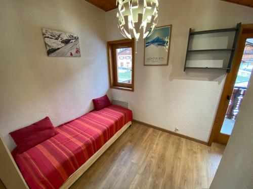 - un canapé dans une chambre dotée d'une fenêtre et d'un lustre dans l'établissement Appt lumineux avec mezzanine, 2 balcons, à 200m des télésièges - FR-1-693-44, à Châtel