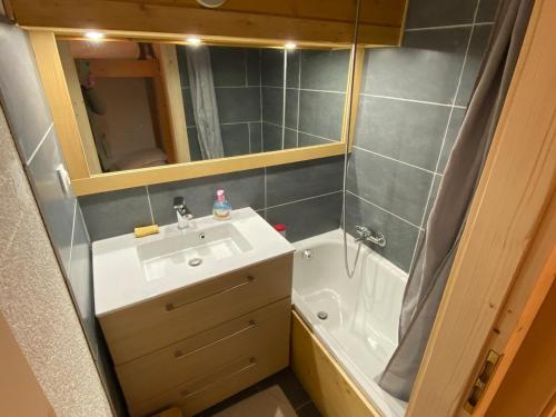 une salle de bain avec un lavabo, un miroir et une baignoire dans l'établissement Appt lumineux avec mezzanine, 2 balcons, à 200m des télésièges - FR-1-693-44, à Châtel