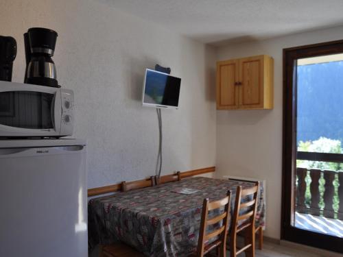- une petite salle à manger avec une table et un four micro-ondes dans l'établissement Appart 1er étage à Châtel, 650m du centre, park. privé, Multi Pass inclus - FR-1-693-52, à Châtel