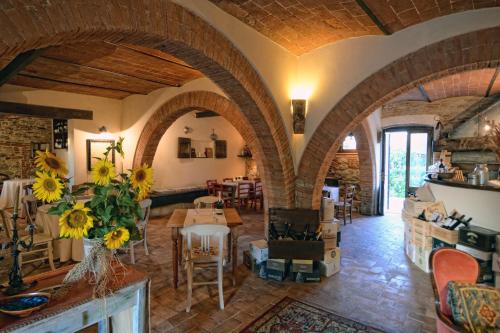 sala de estar con arcos, mesa y sillas en Casale Baldelli Apartments, en Castiglione del Lago