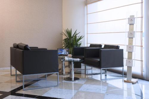 a waiting room with black chairs and a table at My One Hotel Bologna in Bologna
