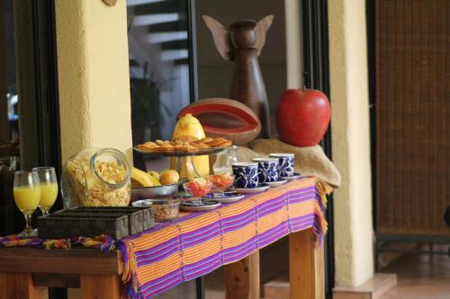 a table with a buffet of food and an apple on it at Hotel La Posada del Angel in San Salvador