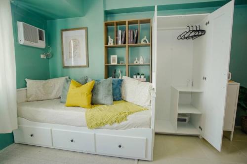 ein Schlafzimmer mit grünen Wänden und einem Bett mit gelben Kissen in der Unterkunft Vicar Home by Serin East Tagaytay in Tagaytay