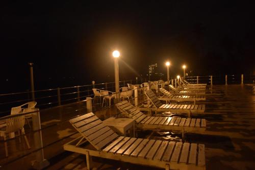 a row of benches on a pier at night at New Ocean Hill Hotel in Hikkaduwa