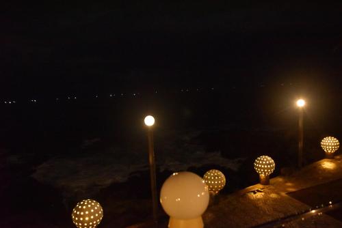 a group of balloons sitting next to street lights at night at New Ocean Hill Hotel in Hikkaduwa