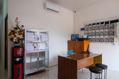 an office with a desk and a refrigerator at RedDoorz near Alun Alun Magelang 2 in Magelang