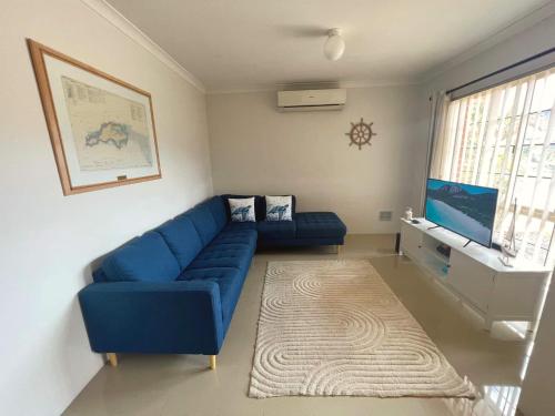 a living room with a blue couch and a rug at Beachside Retreat 2 in Rockingham