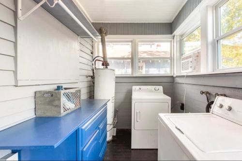 a laundry room with a blue counter and a washing machine at Cozy Yellow Home near LSU and Downtown in Baton Rouge