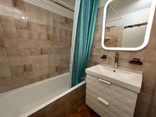 y baño con lavabo, bañera y espejo. en Studio Châtel, 1 pièce, 4 personnes - FR-1-693-55, en Châtel