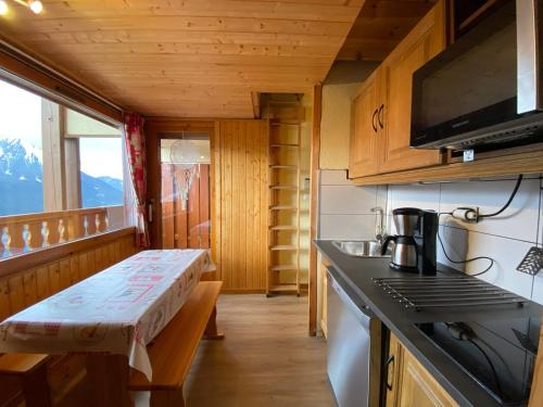 - une cuisine avec un banc dans une petite maison dans l'établissement Appartement cosy avec balcon et WIFI proche télésiège - FR-1-693-68, à Châtel