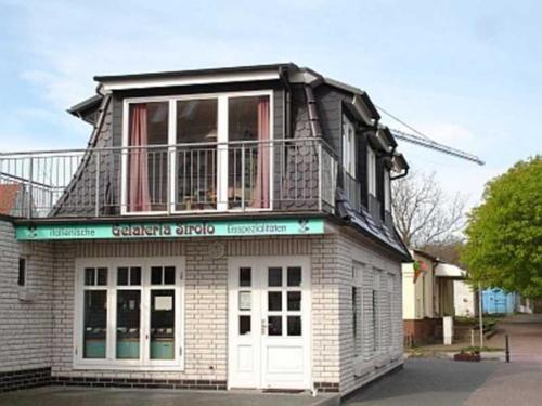 a building with a balcony on top of it at Ruegen Fewo 111 in Drewoldke