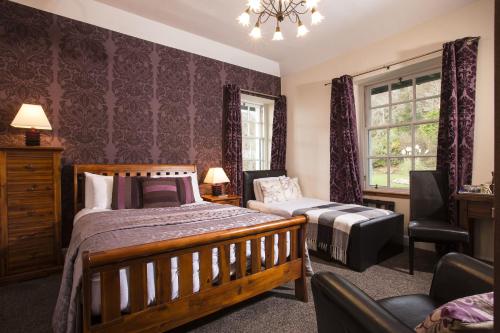 a bedroom with a bed and a chair and a window at North Kessock Hotel in Inverness