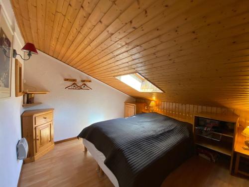 um quarto com uma cama grande e um tecto em madeira em Appartement Châtel, 2 pièces, 4 personnes - FR-1-693-70 em Châtel