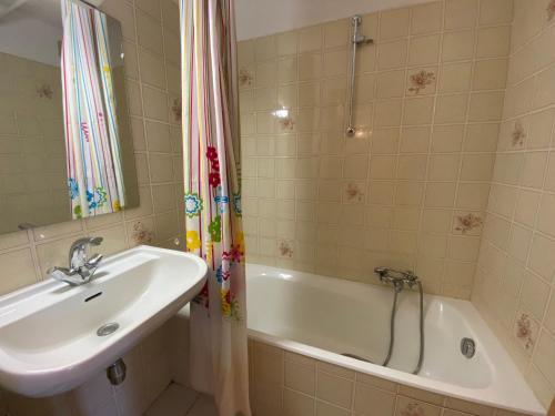 une salle de bain avec un lavabo et une baignoire et un lavabo dans l'établissement Studio confortable près du centre avec balcon et parking - FR-1-693-74, à Châtel