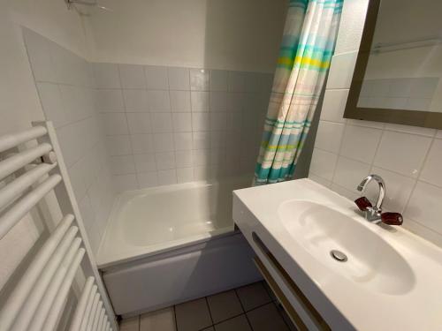 a white bathroom with a sink and a bath tub at Appartement cosy avec balcon, WIFI et parking à Châtel - FR-1-693-80 in Châtel