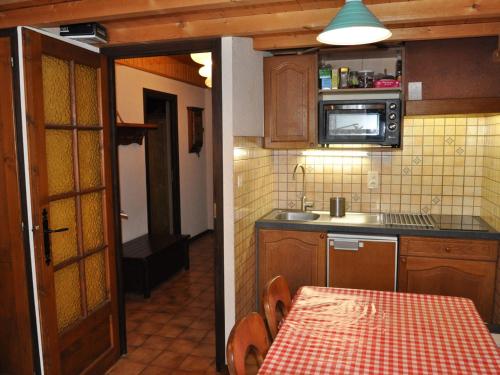 une petite cuisine avec une table et un micro-ondes dans l'établissement Charmant 2 pièces avec mezzanine près des remontées, balcon sud, parking couvert, La Chapelle-d'Abondance - FR-1-692-8, à La Chapelle-dʼAbondance