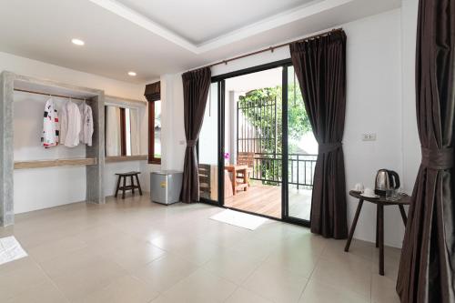 een woonkamer met een deur naar een balkon bij Ibiza Bungalows in Haad Yao