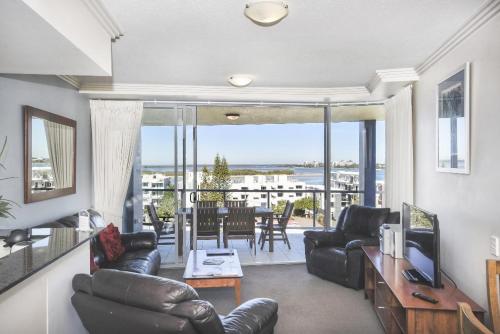 a living room with leather furniture and a view of the ocean at Pumicestone Blue Resort in Caloundra