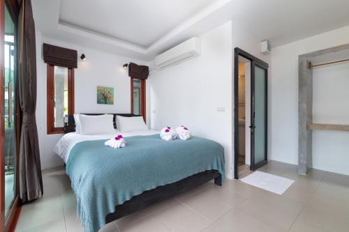a bedroom with a bed with two cats on it at Ibiza Bungalows in Haad Yao