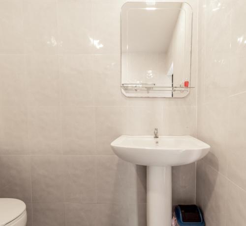 a white bathroom with a sink and a mirror at Ibiza Bungalows in Haad Yao