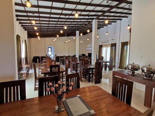 a restaurant with wooden tables and chairs and a room with tables and chairs at Y Villa Residencies in Galle
