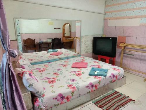 um quarto com 2 camas e uma televisão em Kanjana Resort em Surat Thani