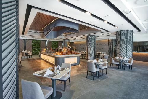 a rendering of a restaurant with tables and chairs at Hotel Holiday International in Sharjah