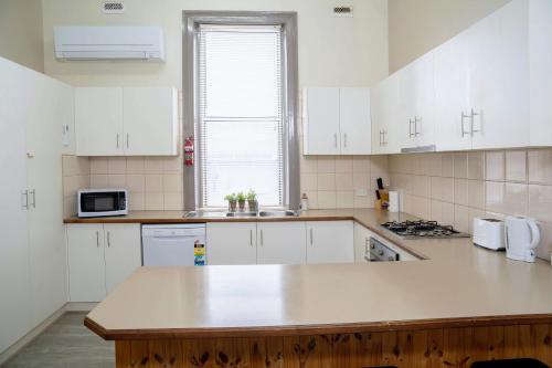 a kitchen with white cabinets and a counter top at #Grampians Views Getaway #CBD #Netflix in Stawell