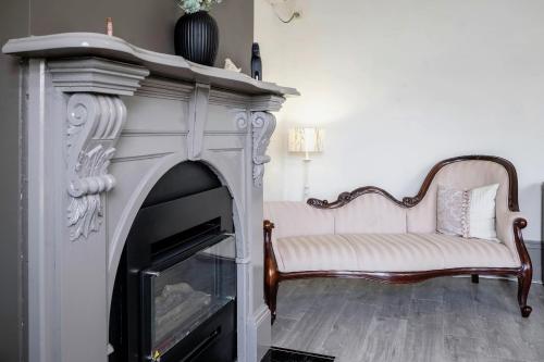 a living room with a fireplace and a white couch at #Grampians Views Getaway #CBD #Netflix in Stawell