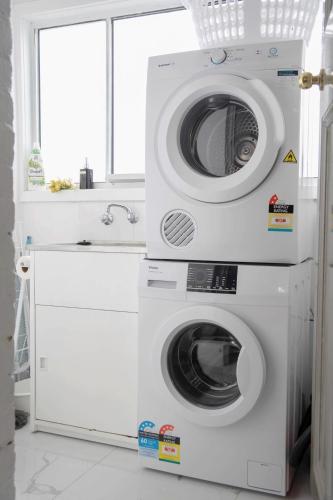 two washing machines and a washer and dryer in a bathroom at #Grampians Views Getaway #CBD #Netflix in Stawell