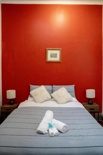 a bed with two towels on it with a red wall at #Grampians Views Getaway #CBD #Netflix in Stawell