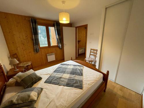 une chambre avec un lit avec une couverture dessus dans l'établissement Charmant appartement 2 pièces avec parking et animaux admis à La Chapelle-d'Abondance - FR-1-692-35, à La Chapelle-dʼAbondance