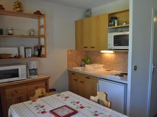 une petite cuisine avec une table et un micro-ondes dans l'établissement Charmant 2 pièces calme avec balcon, proche pistes! - FR-1-692-70, à Abondance