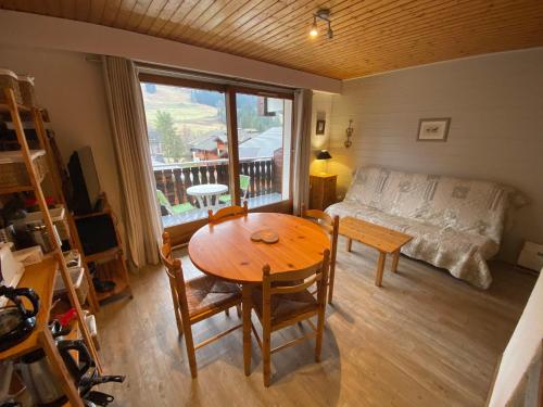 un salon avec une table et un canapé dans l'établissement Studio spacieux près des pistes, balcon sud, parking, casier à skis et coin montagne! - FR-1-692-31, à La Chapelle-dʼAbondance