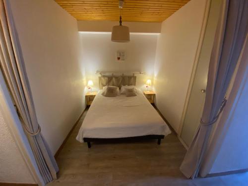 a bedroom with a bed and two lamps on two tables at Studio spacieux au pied des pistes avec casier à skis - FR-1-692-31 in La Chapelle-dʼAbondance