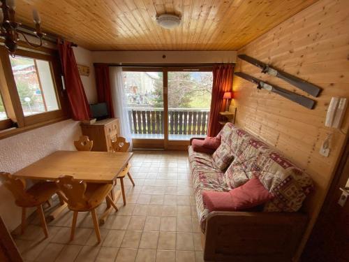 un salon avec un canapé et une table dans l'établissement Studio 28m² près des pistes avec balcon, casier à skis et parking. - FR-1-692-54, à La Chapelle-dʼAbondance
