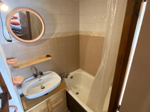 een badkamer met een wastafel, een bad en een spiegel bij Studio Abondance, 1 pièce, 4 personnes - FR-1-692-55 in Abondance