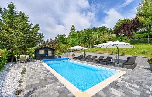 a swimming pool with chairs and umbrellas in a backyard at Awesome Home In Novi Marof With Outdoor Swimming Pool in Novi Marof