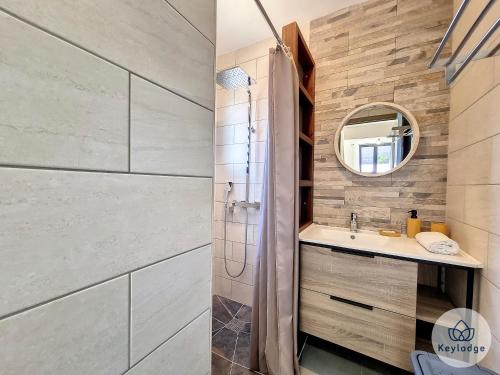 ein Bad mit einer Dusche, einem Waschbecken und einem Spiegel in der Unterkunft Villa Exotika - 68m2 - Entre-Deux in Entre-Deux