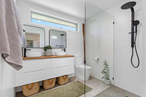 a bathroom with a toilet and a sink and a shower at PERIWINKLE - MOUNT MARTHA in Mount Martha